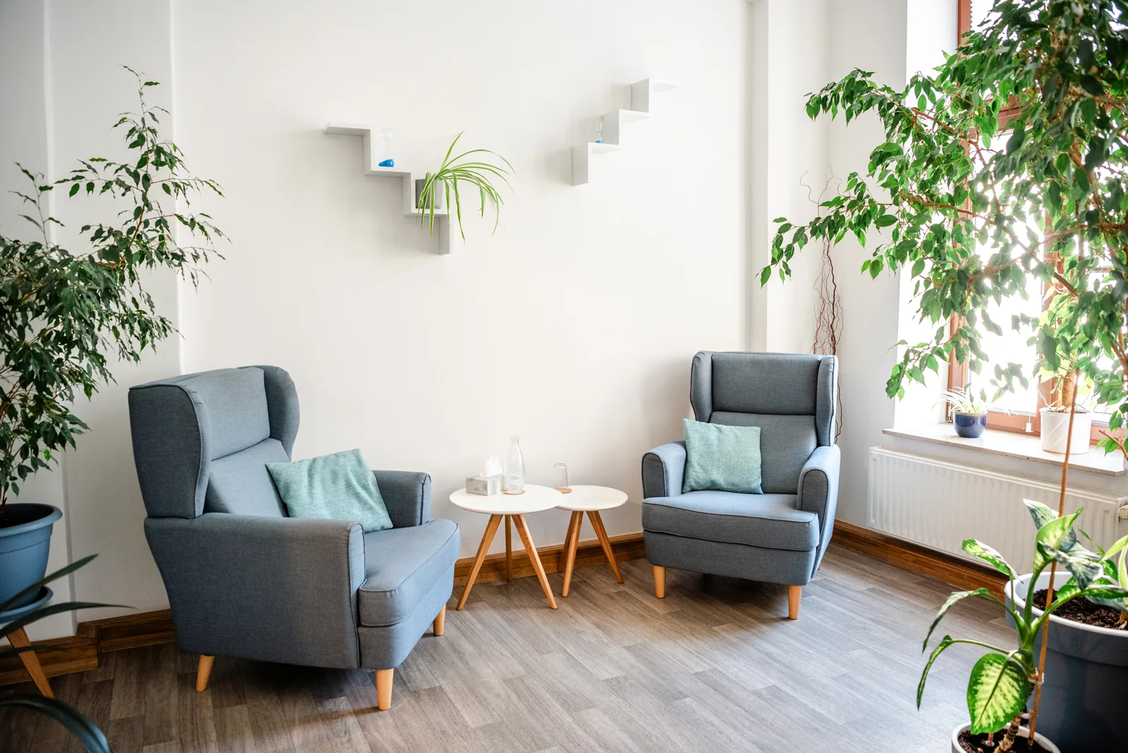 Light-filled therapy room with two grey armchairs